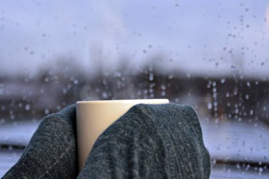 yağmurlu bir günde bir fincan çay tutmak  