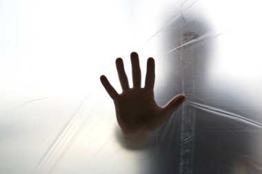 Bir hayalet el şeffaf plastik arkasında silüeti 