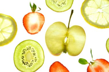 Portakal, çilek ve kivi gibi farklı dilimlenmiş meyveler parlak beyaz bir arka plan üzerinde yatıyor ve ışık ile yukarıdan aydınlatılır - farklı renklerde taze ve sağlıklı meyve kavramı - 