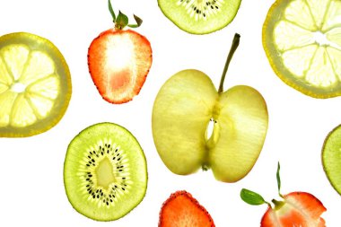 Portakal, çilek ve kivi gibi farklı dilimlenmiş meyveler parlak beyaz bir arka plan üzerinde yatıyor ve ışık ile yukarıdan aydınlatılır - farklı renklerde taze ve sağlıklı meyve kavramı - 