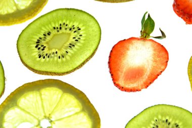 Portakal, çilek ve kivi gibi farklı dilimlenmiş meyveler parlak beyaz bir arka plan üzerinde yatıyor ve ışık ile yukarıdan aydınlatılır - farklı renklerde taze ve sağlıklı meyve kavramı - 