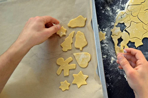 Man's hands baking Christmas gingerbread cookies on a table