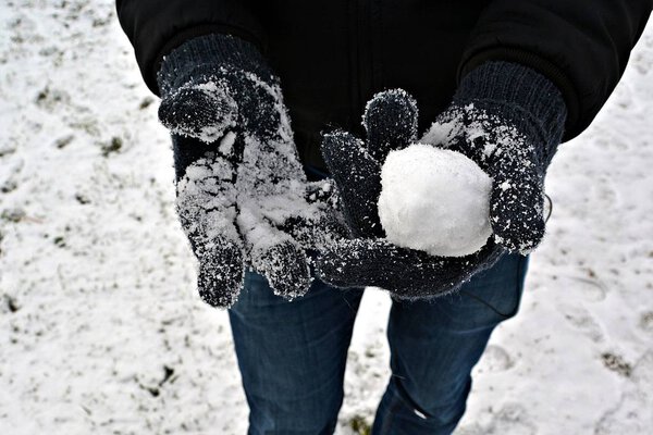 close up - form a snow ball with gloves in winter 