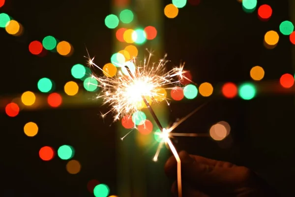 Segurando Sparkler Frente Uma Fada Luzes Coloridas — Fotografia de Stock