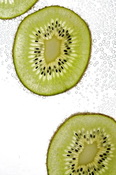 Een Gesneden Kiwi Ligt Een Lichte Achtergrond Door Dunne Kiwi — Stockfoto