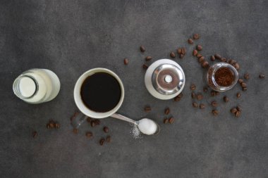  yanında süt ve şeker ile bir fincan kahve 