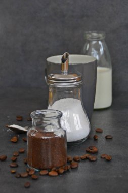  yanında süt ve şeker ile bir fincan kahve 