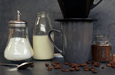  yanında süt ve şeker ile bir fincan kahve 