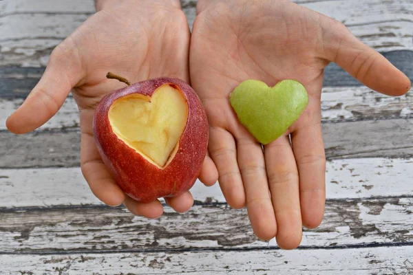 Vasthouden Van Appel Met Een Hart Vorm Uitgesneden Handen — Stockfoto