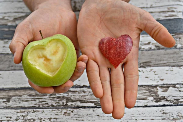 Holding apple with a heart shape cut out in hands