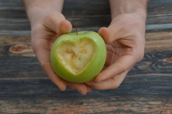 Holding apple with a heart shape cut out in the hand