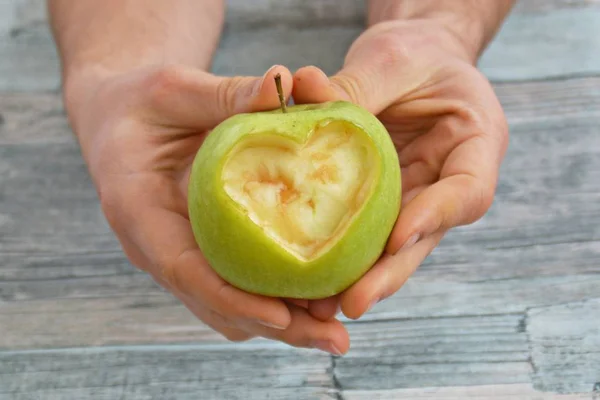 Holding apple with a heart shape cut out in the hand