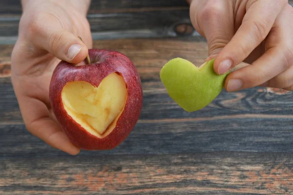 Holding apple with a heart shape cut out in hands