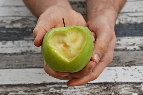 Holding apple with a heart shape cut out in hands