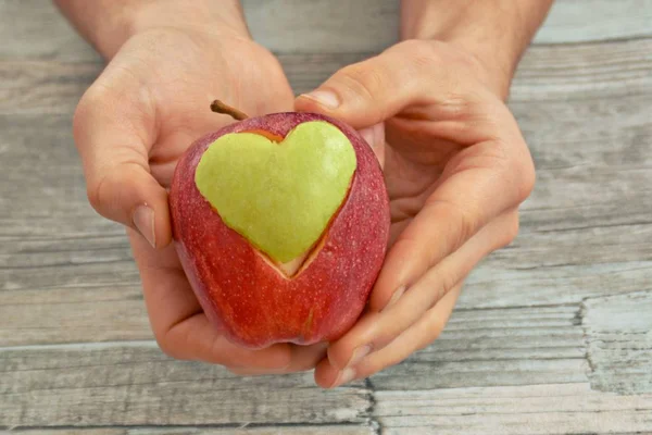 Vasthouden Van Appel Met Een Hart Vorm Uitgesneden Handen — Stockfoto