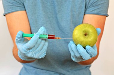 yeşil bir elma içine kırmızı ilaç enjekte 