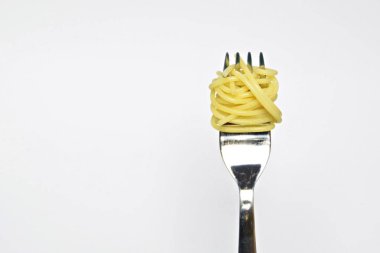 Spagetti beyaz arka plan karşı bir çatal üzerinde sarılmış