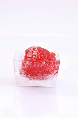 Beyaz arka planda buz küpü içinde Ahududu