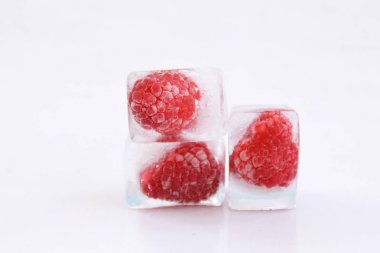 Beyaz arka planda buz küpleri içinde Ahududu