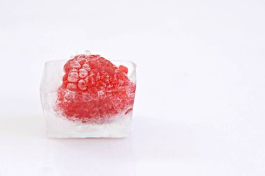 Beyaz arka planda buz küpü içinde Ahududu