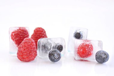 koyu bir arka plan üzerinde buz küpleri halinde dondurulmuş çilek 