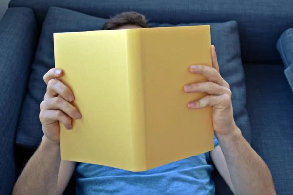 Adam Kanepede Bir Kitap Okuyor — Stok fotoğraf