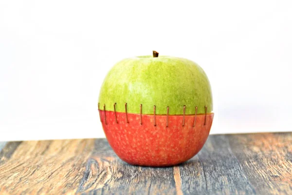 緑のリンゴの上を赤いリンゴの尻と組み合わせて縫い合わせる — ストック写真