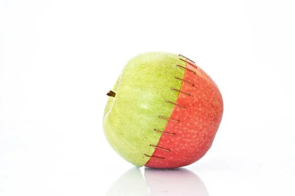 将绿色苹果的顶部与红色苹果的圆锥体混合在一起 将它们缝合在一起 — 图库照片