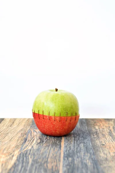 将绿色苹果的顶部与红色苹果的圆锥体混合在一起 将它们缝合在一起 — 图库照片