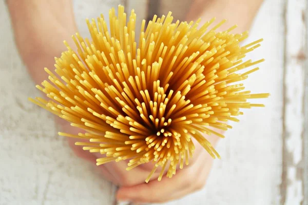 elinde pişmemiş spagetti tutarak