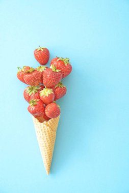 Renkli bir arka plan üzerinde çilek ile dondurma konisi -