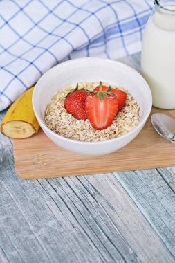 Sabahları sağlıklı bir kahvaltı olarak bir kase çilek ile yulaf ezmesi