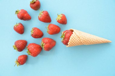 Renkli bir arka plan üzerinde çilek ile dondurma konisi -