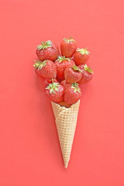 Renkli bir arka plan üzerinde çilek ile dondurma konisi -