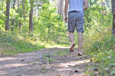 Ayaklarda yakın çekim - ormanda çakıl bir yol boyunca yürür ve yazlık sıcaklıklarda doğada rahatlatır