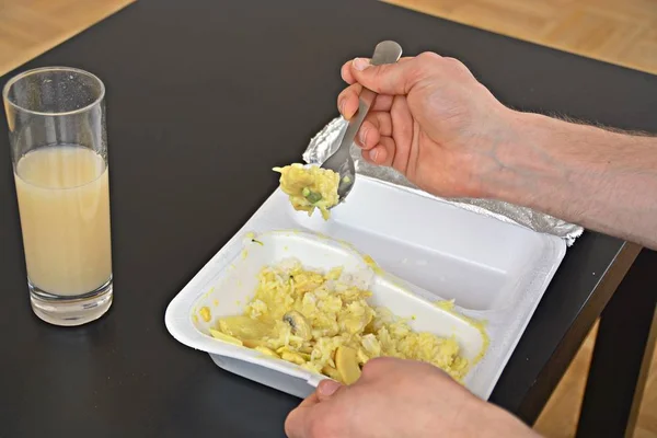 Close-up: eat yellow curry with rice from a styrofoam box with chopsticks