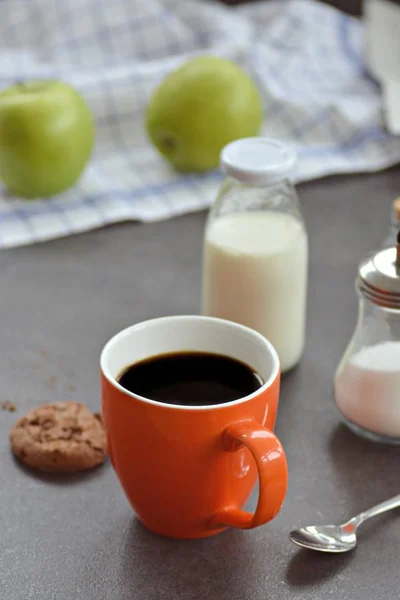 リンゴ ミルク ビスケットを入れたテーブルの上のオレンジカップのコーヒー — ストック写真
