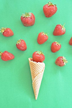 Renkli bir arka plan üzerinde çilek ile dondurma konisi