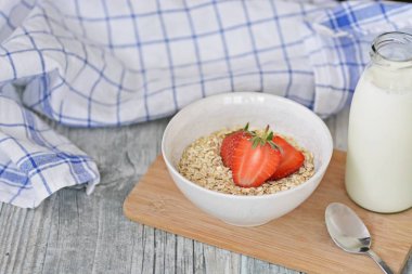 Sabahları sağlıklı bir kahvaltı olarak bir kase çilek ile yulaf ezmesi 