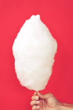 Close-up - adam elinde tek renkli arka plan önünde bir Alman kermis pamuk şeker tutar