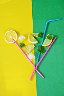 Yaz içkisi konsepti - Pipetler limon, limon, nane ve buz renkli bir arka plan üzerinde yüzen cam makyaj - metin için alan ile yazlık bir ferahlık Soyut illüstrasyon 