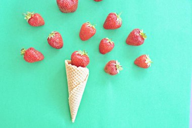 Renkli bir arka plan üzerinde çilek ile dondurma konisi
