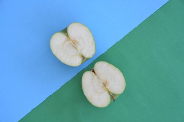 İki farklı renkli arka plan üzerinde bir elma iki yarısı