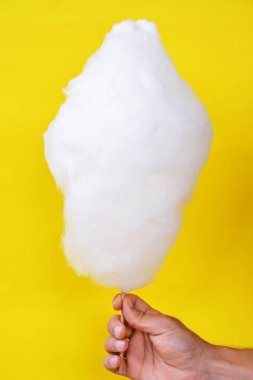 Close-up - adam elinde tek renkli arka plan önünde bir Alman kermis pamuk şeker tutar