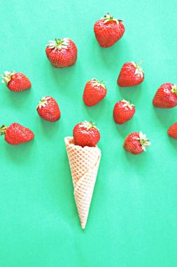 Renkli bir arka plan üzerinde çilek ile dondurma konisi