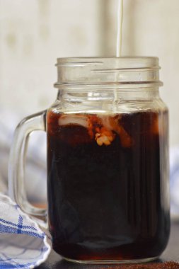 bir buzlu kahve içine süt dökün