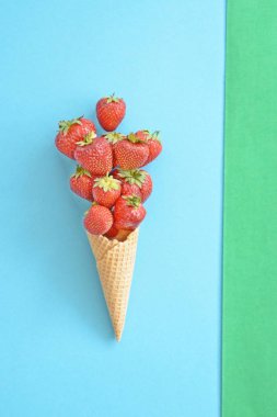 Renkli bir arka plan üzerinde çilek ile dondurma konisi