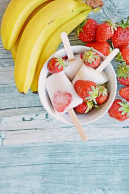 Süt, muz ve çilek ile ev yapımı buzlu şekerler 