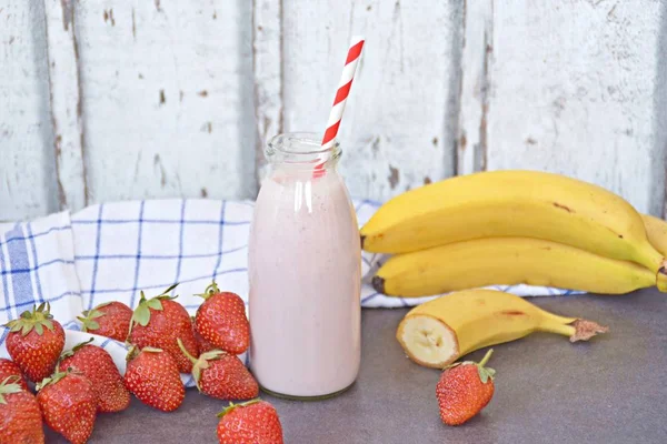 Homemade milk shake with strawberries and bananas as a perfect refreshment in summer