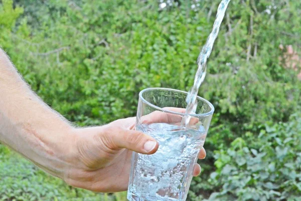 Friskt Och Rent Vatten Rinner Ett Glas Framför Grön Somrig — Stockfoto